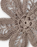 Zbliżenie jasnobrązowej broszki szydełkowej kwiat handmade