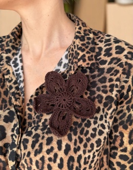 Brązowa broszka szydełkowa kwiat handmade noszona przez modelkę